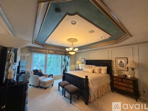 A bedroom with a large bed and a chandelier.