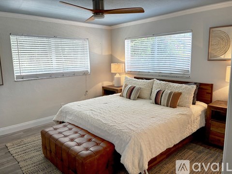 A bedroom with a large bed and a ceiling fan.
