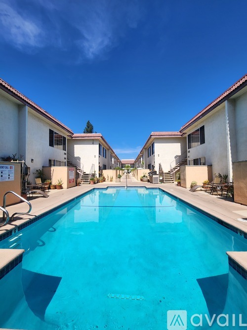 A swimming pool in front of a building with the logo "avail" on the bottom right.