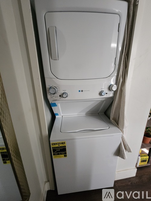 A white dryer is sitting in a small space.
