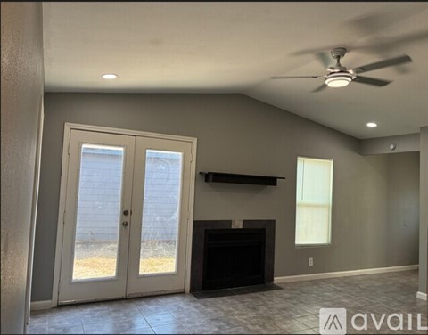 A living room with a fireplace and a ceiling fan.