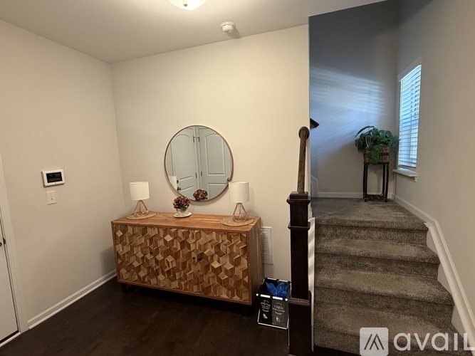 A hallway with a staircase leading to a bedroom.