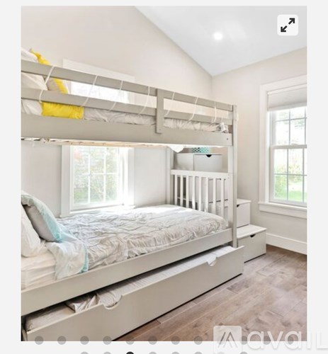 A white bedroom with a bunk bed and a window.
