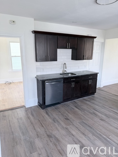 A kitchen with dark wood cabinets and a white countertop.