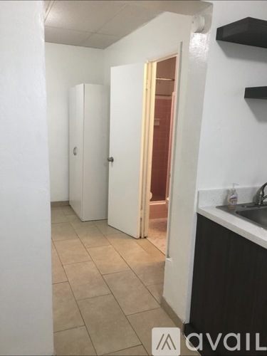 A kitchen area with a sink and a refrigerator.