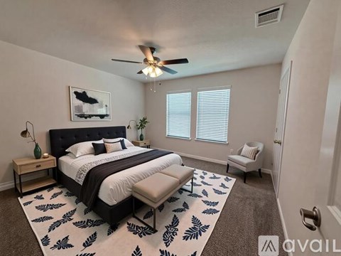 A bedroom with a large bed and a ceiling fan.