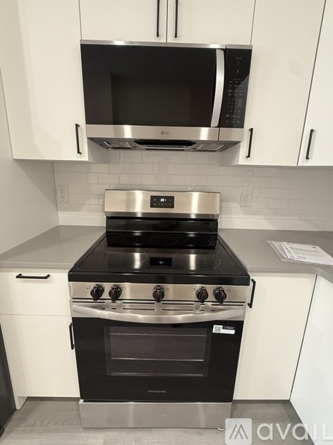 A modern kitchen with a stove top oven and microwave above it.