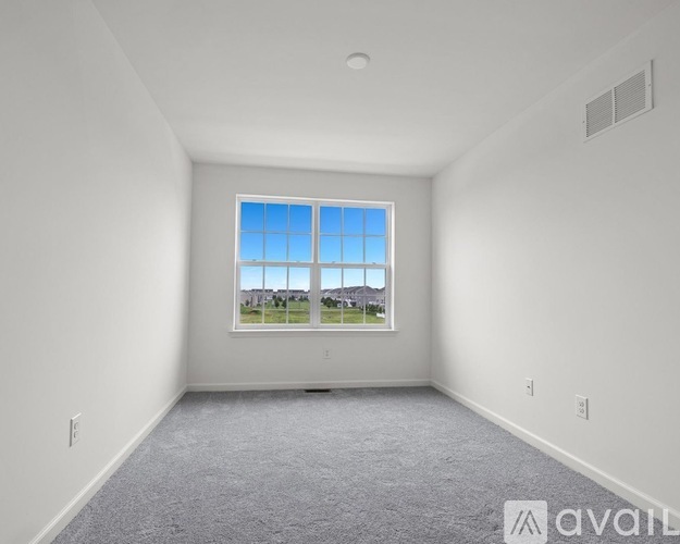 A room with a large window overlooking a grassy area.