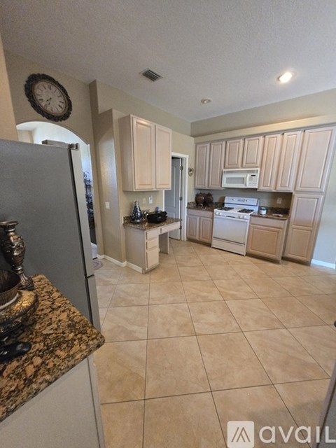 A kitchen with a refrigerator, microwave, oven, and cabinets.