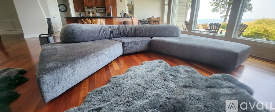 A grey sectional sofa in a living room with a view of the ocean.