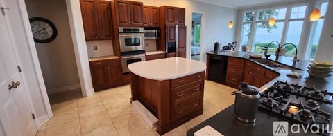A kitchen with wooden cabinets and a large island.