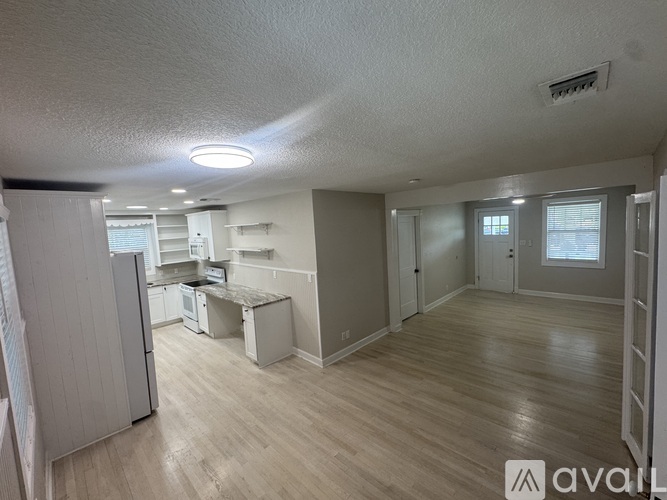 A kitchen area with a refrigerator, sink, and cabinets.