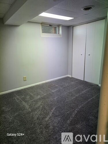 A room with grey carpet and white walls.