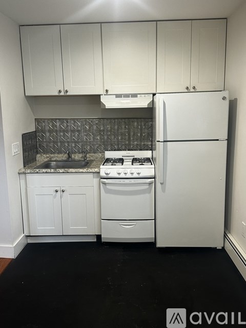 A kitchen with white appliances and cabinets.