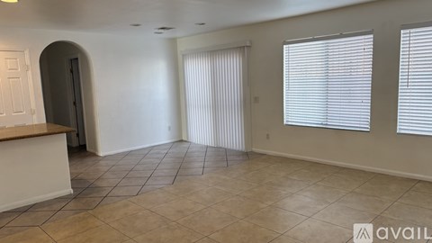 A spacious room with tiled flooring and a counter in the foreground.