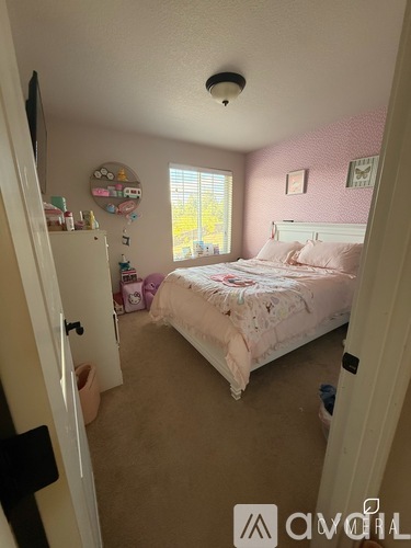 A bedroom with a bed, dresser, and window.