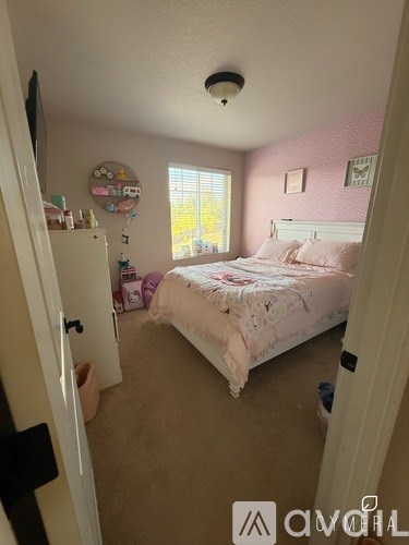 A bedroom with a bed, dresser, and window.