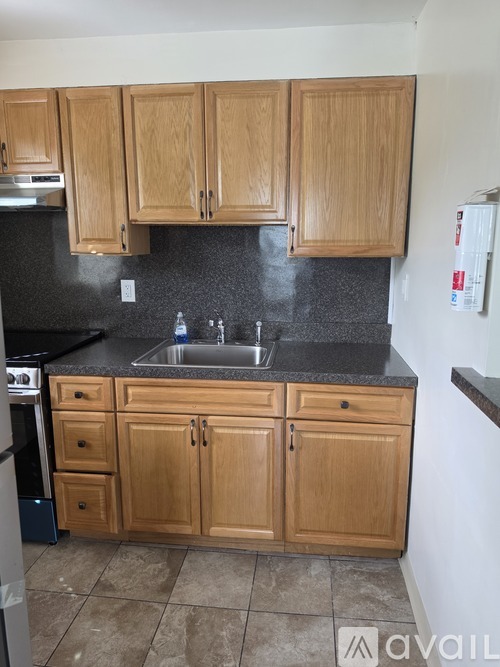 A kitchen with wooden cabinets and a black countertop.