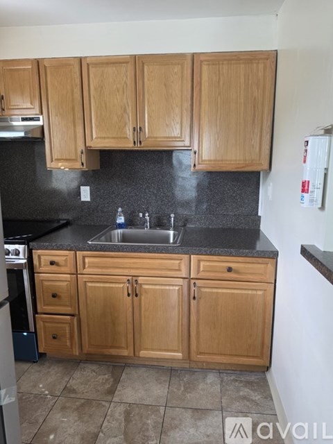 A kitchen with wooden cabinets and a black countertop.