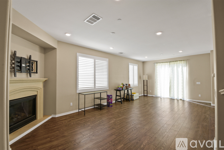 A spacious living room with a fireplace and a dining table set up.