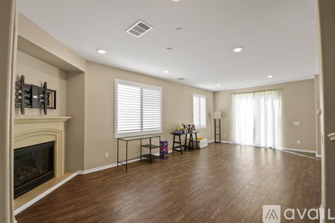 A spacious living room with a fireplace and a dining table set up.