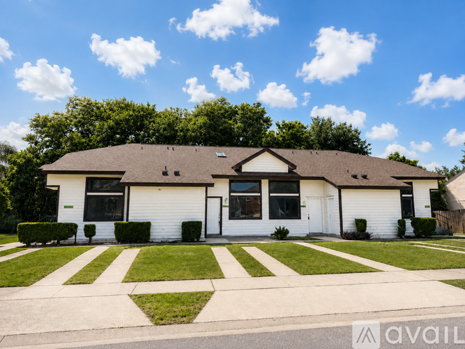 A house with a white exterior and a brown roof is for sale.