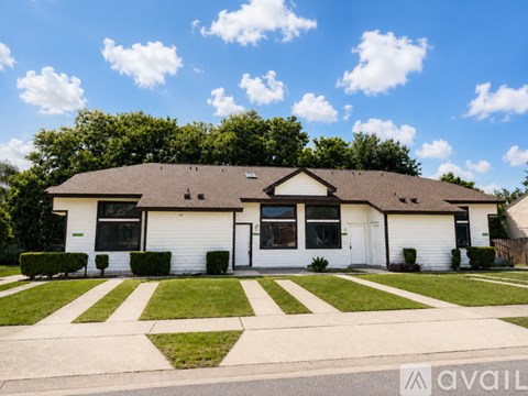 A house with a white exterior and a brown roof is for sale.