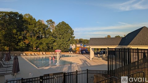 A pool area with people swimming and sun loungers.