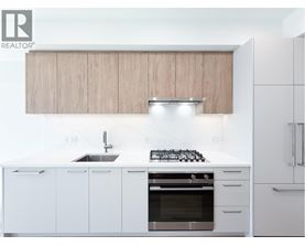 A modern kitchen with white cabinets and a stainless steel oven.