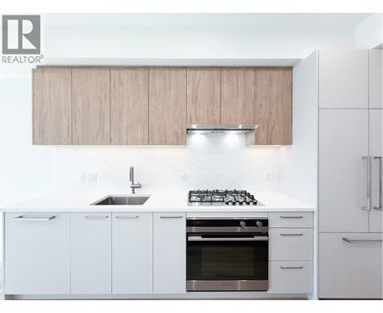 A modern kitchen with white cabinets and a stainless steel oven.
