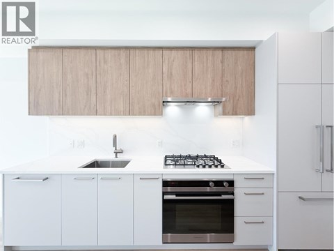 A modern kitchen with white cabinets and a stainless steel oven.