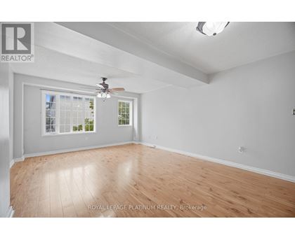 A room with a ceiling fan and a window with a view of trees.