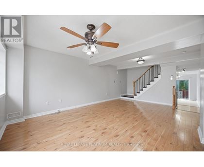 A spacious room with a ceiling fan and wooden flooring.