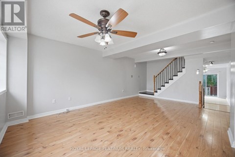 A spacious room with a ceiling fan and wooden flooring.