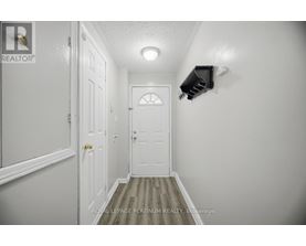 A hallway with a door and a light on the wall.