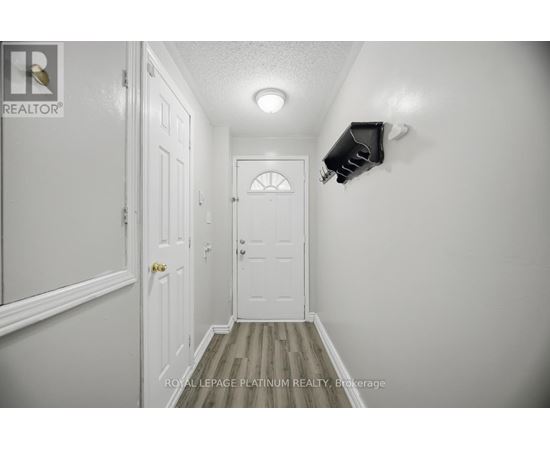 A hallway with a door and a light on the wall.