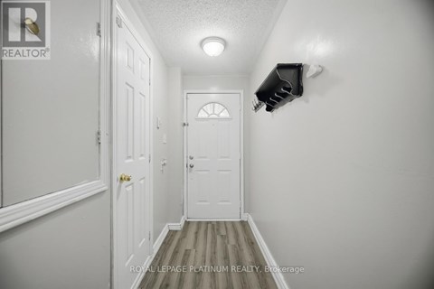 A hallway with a door and a light on the wall.