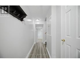 A long hallway with white walls and doors on both sides.