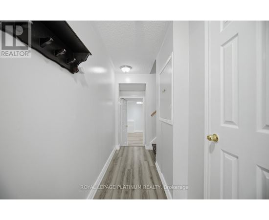 A long hallway with white walls and doors on both sides.