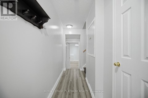 A long hallway with white walls and doors on both sides.