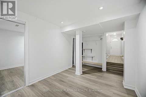 A white bedroom with a bed and a wardrobe.