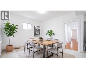 A dining room with a table and chairs.