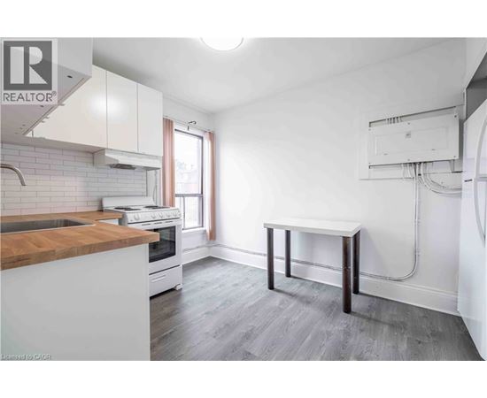 A kitchen with a white counter and a wooden island.