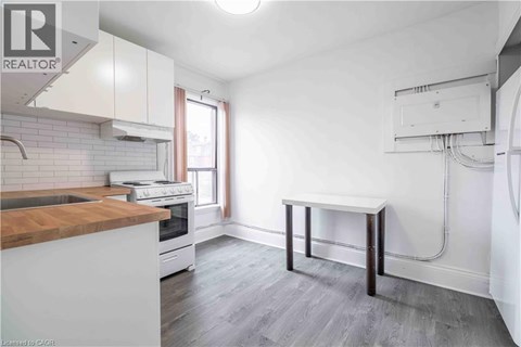A kitchen with a white counter and a wooden island.