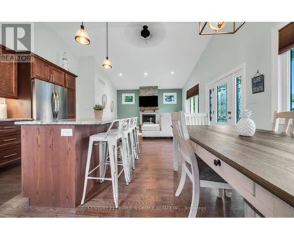 A kitchen with wooden cabinets and a long island with bar stools.
