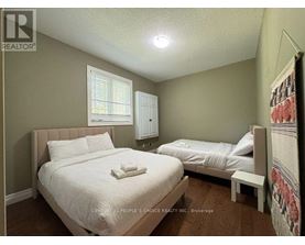 A bedroom with two beds and a window.