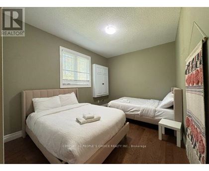 A bedroom with two beds and a window.