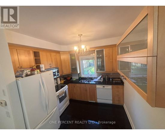 A kitchen with wooden cabinets and a white refrigerator.