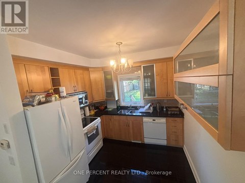 A kitchen with wooden cabinets and a white refrigerator.