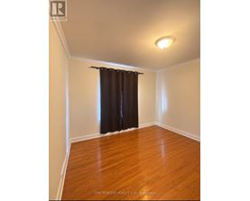 A room with a brown curtain and wooden floor.